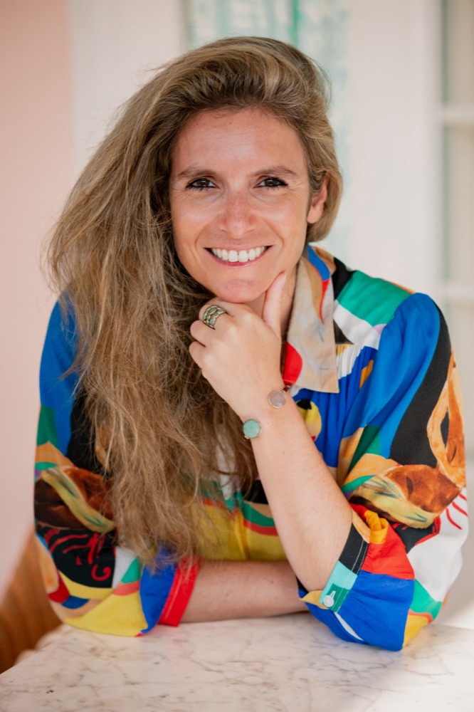 Caroline Arditti, souriante, le menton posé sur la main.